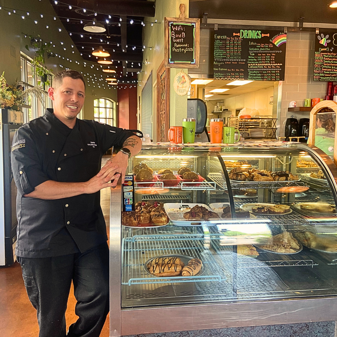 Xavier Gonzales-Graybill stands in front a bakery case.