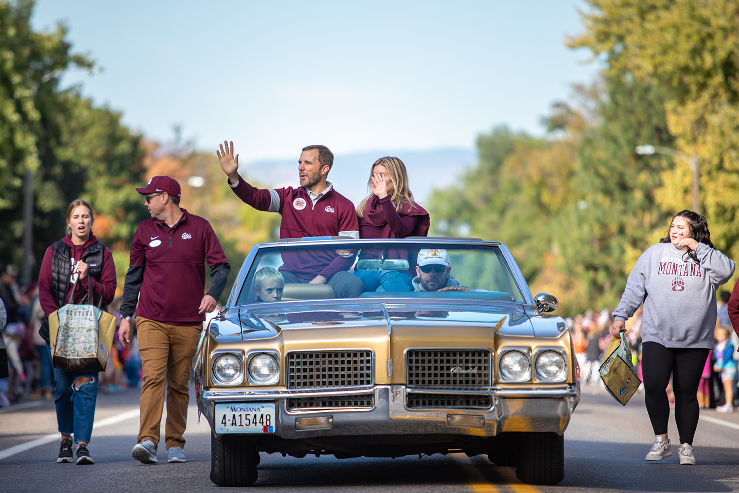 President Bodnar and Dr. Chelsea Bodnar waving from a car during the Homecoming Parde.