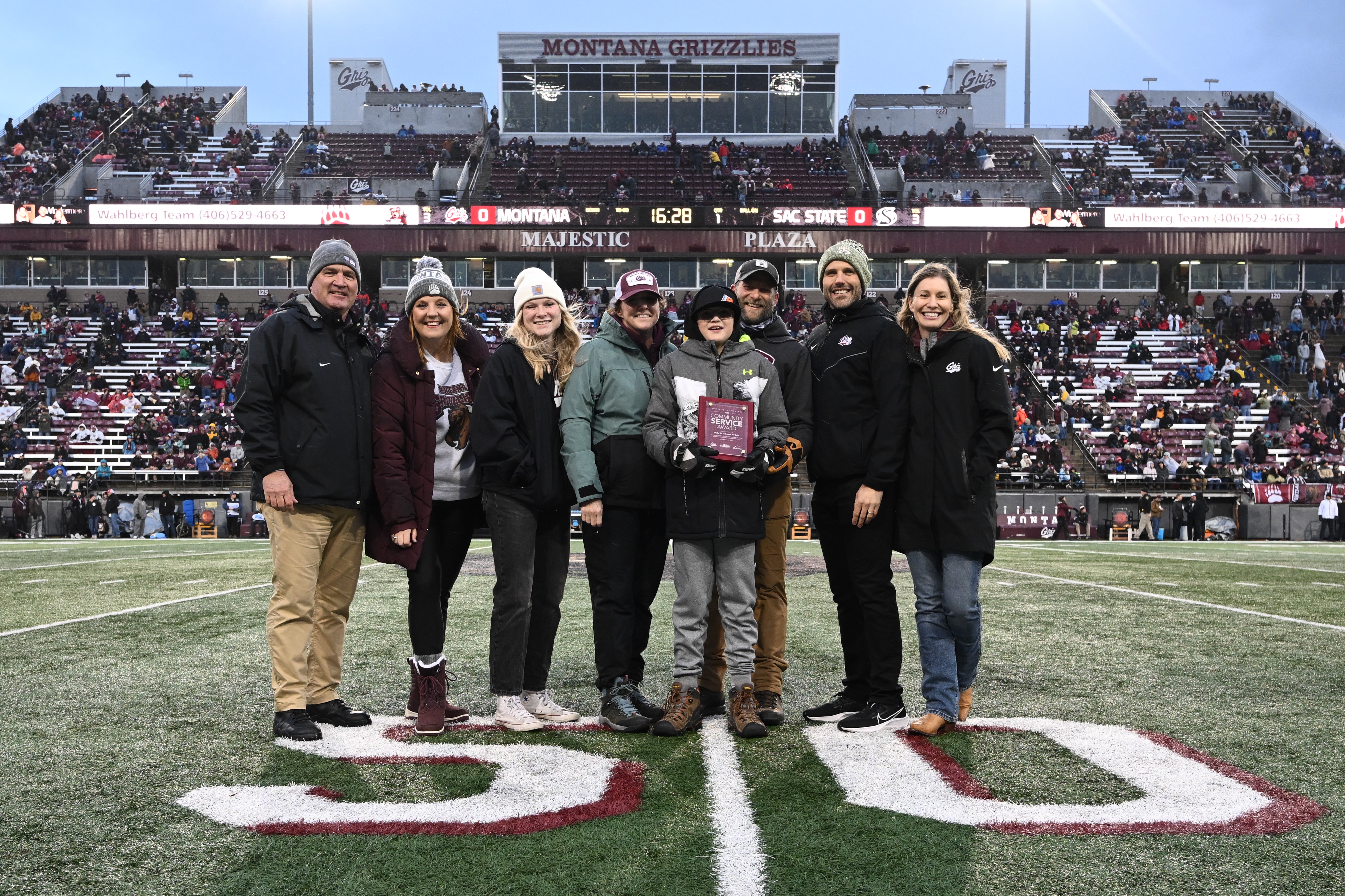 Beth and Brian Toone on field with University dignitaries