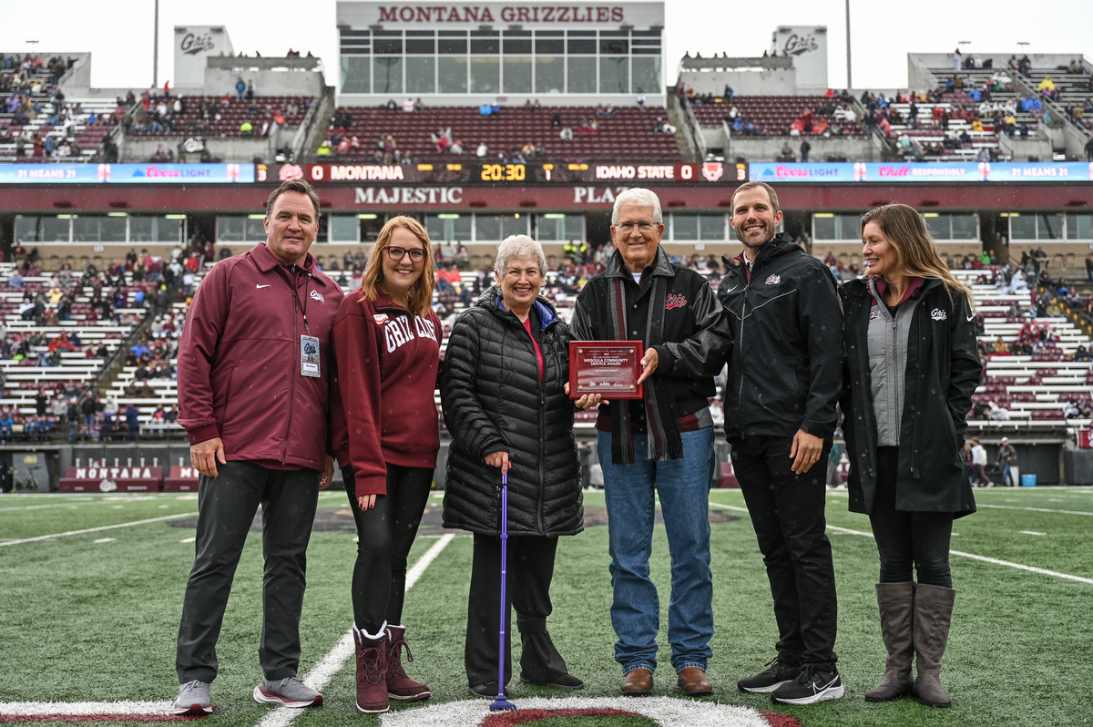Gary and Judy Hughes on field with University dignitaries